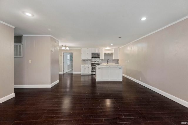 unfurnished living room with dark hardwood / wood-style flooring, a notable chandelier, crown molding, and sink