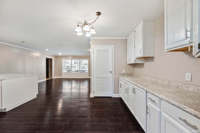 kitchen featuring white cabinetry, decorative light fixtures, dark wood-type flooring, and light stone countertops