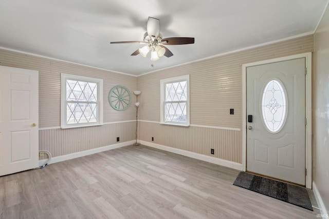 entryway with ceiling fan, ornamental molding, and light hardwood / wood-style flooring