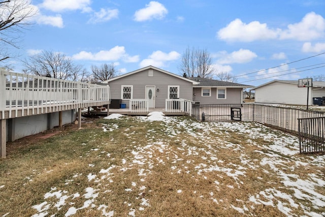 snow covered back of property featuring a wooden deck