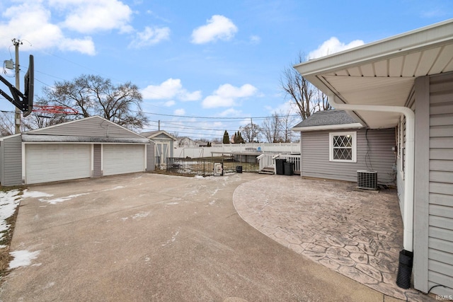 exterior space featuring a garage, central AC, and an outbuilding