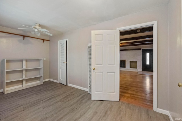 spare room featuring hardwood / wood-style flooring, ceiling fan, and beamed ceiling