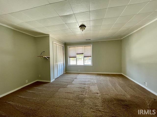 unfurnished bedroom featuring crown molding and carpet flooring