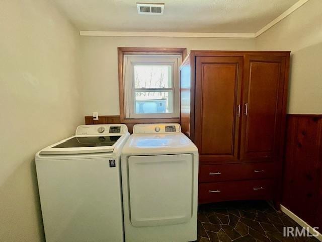 laundry room featuring cabinets, independent washer and dryer, ornamental molding, and wooden walls