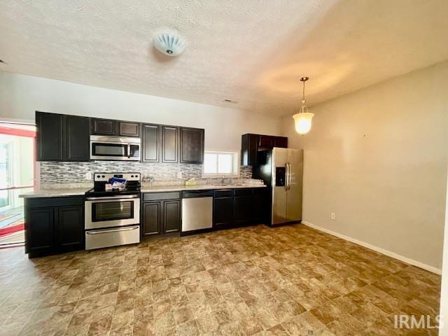 kitchen featuring backsplash, decorative light fixtures, a wealth of natural light, and appliances with stainless steel finishes