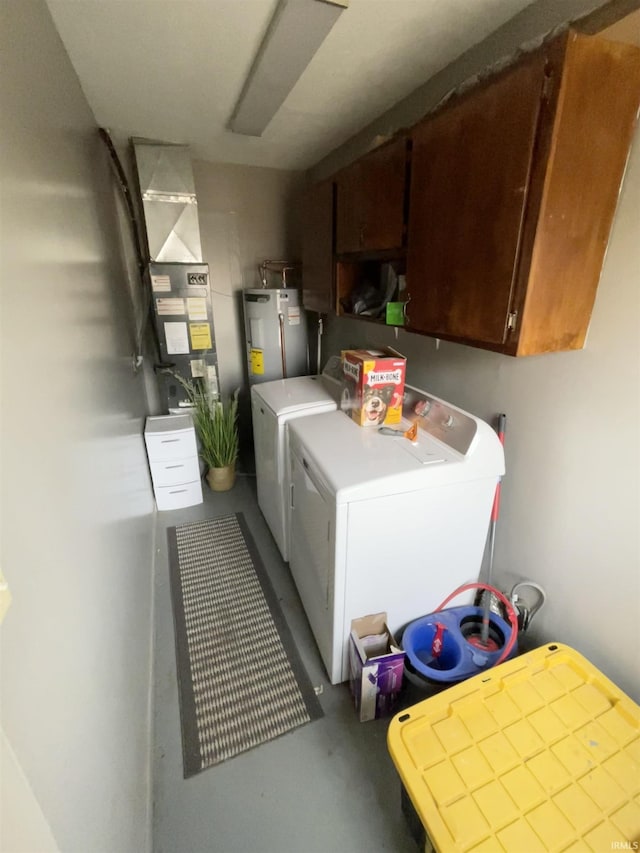 washroom featuring cabinets, washing machine and dryer, and water heater