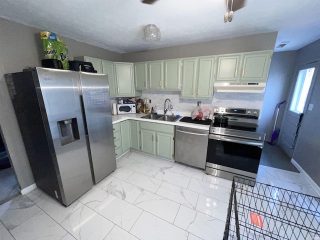 kitchen with green cabinetry, stainless steel appliances, and sink