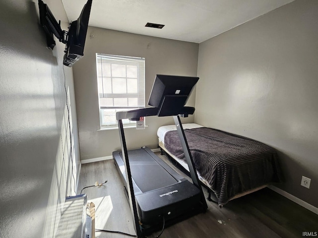 bedroom with dark hardwood / wood-style flooring