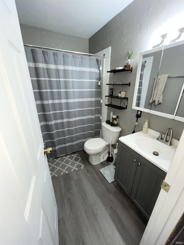 bathroom with hardwood / wood-style flooring, vanity, toilet, and a shower with curtain