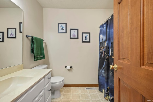 bathroom featuring vanity, a textured ceiling, and toilet