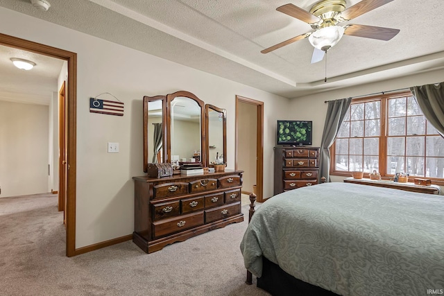 bedroom with ceiling fan, light colored carpet, and a textured ceiling