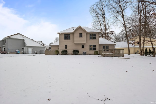 snow covered back of property featuring a deck