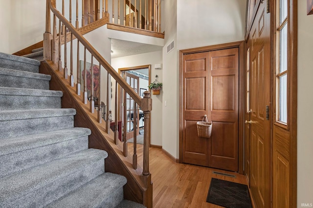 foyer entrance featuring a high ceiling and light hardwood / wood-style floors