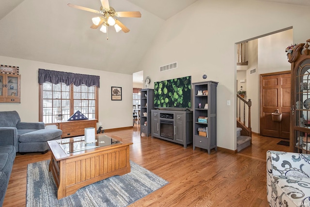 living room with hardwood / wood-style flooring, vaulted ceiling, and ceiling fan