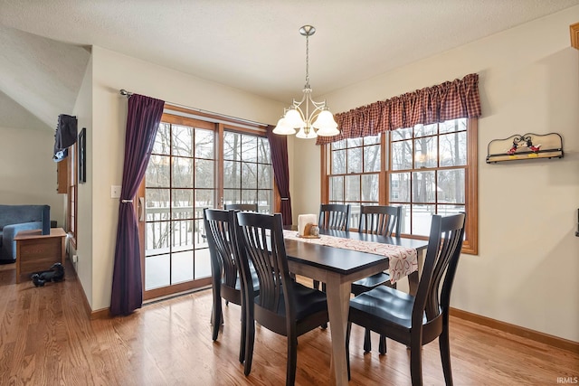 dining space featuring a chandelier, light wood-type flooring, and a wealth of natural light