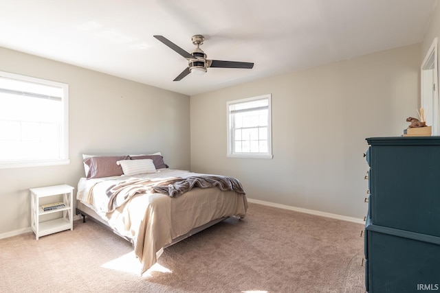 bedroom featuring light carpet, multiple windows, and ceiling fan