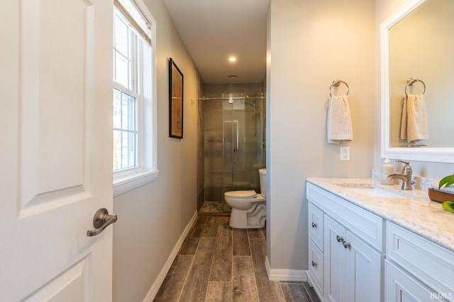 bathroom featuring vanity, a shower with shower door, and toilet