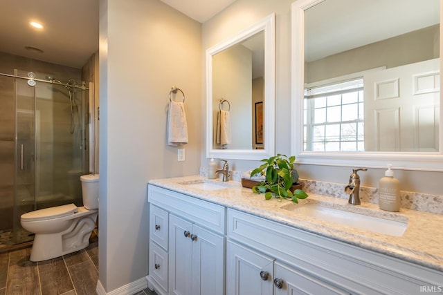 bathroom featuring vanity, toilet, and a shower with door