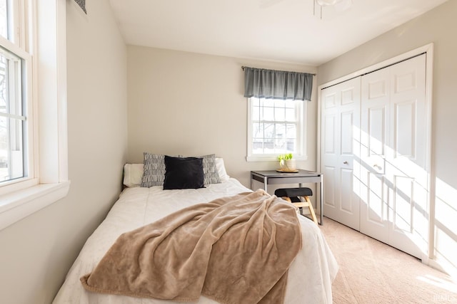 carpeted bedroom featuring ceiling fan and a closet