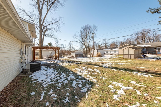 yard covered in snow featuring central air condition unit and a pergola