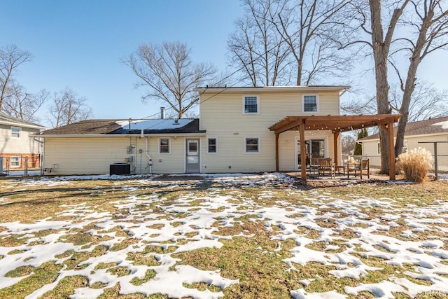 snow covered house featuring a pergola and central air condition unit