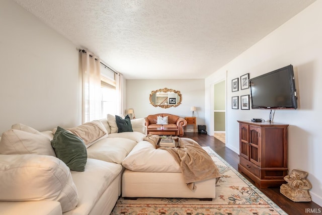 living room with dark wood-type flooring and a textured ceiling