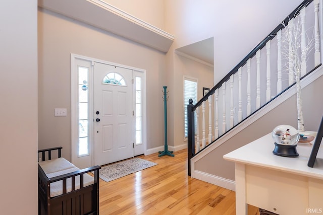 foyer featuring hardwood / wood-style floors and crown molding