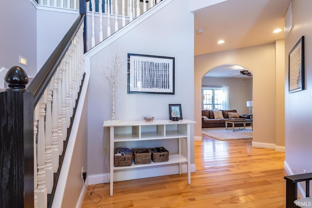 staircase with hardwood / wood-style floors and ceiling fan