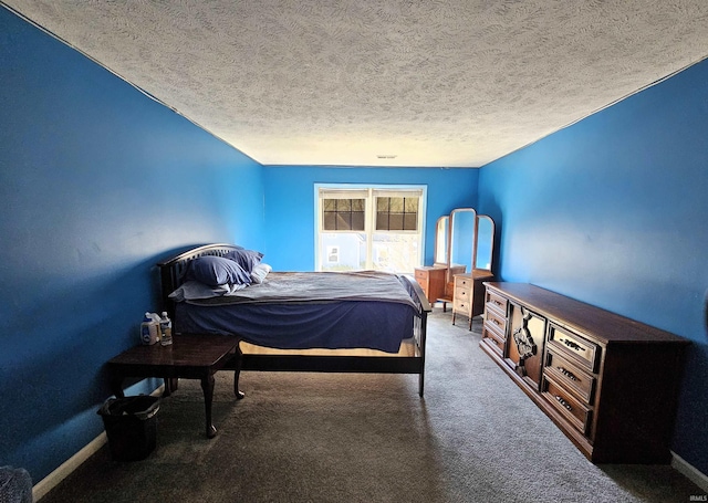 bedroom with dark carpet and a textured ceiling