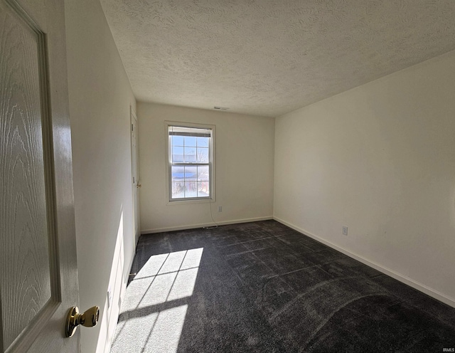 carpeted spare room featuring a textured ceiling