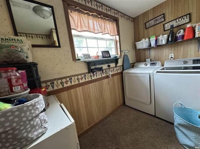 clothes washing area with independent washer and dryer, carpet flooring, and wood walls