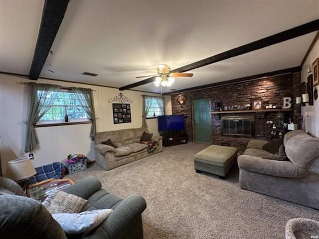 living room with a healthy amount of sunlight, carpet, beamed ceiling, and brick wall