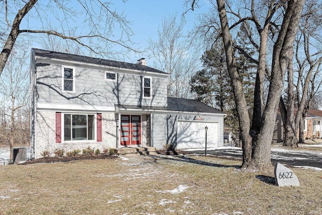 view of front facade featuring an attached garage, a chimney, and brick siding