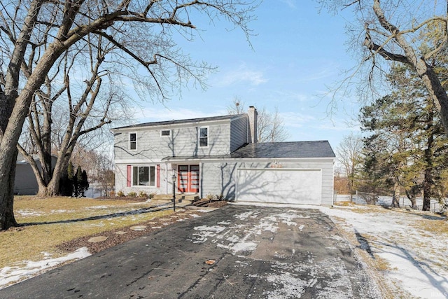 view of front of home with an attached garage, a chimney, and aphalt driveway