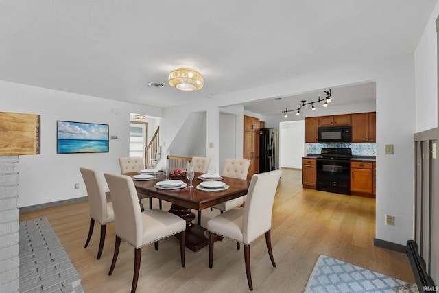 dining area featuring track lighting and light hardwood / wood-style floors