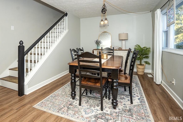 dining space with dark hardwood / wood-style flooring and a textured ceiling