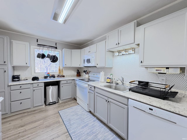 kitchen featuring sink, light wood-type flooring, ornamental molding, white appliances, and decorative backsplash