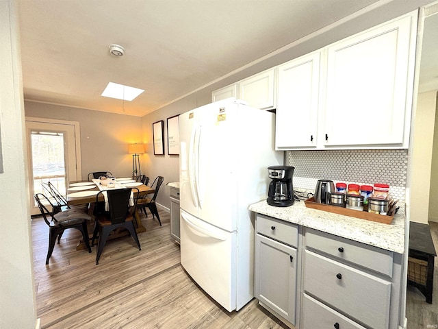 kitchen featuring gray cabinetry, decorative backsplash, white cabinetry, and white refrigerator