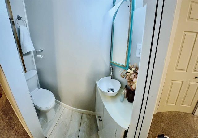 bathroom featuring sink, hardwood / wood-style floors, and toilet