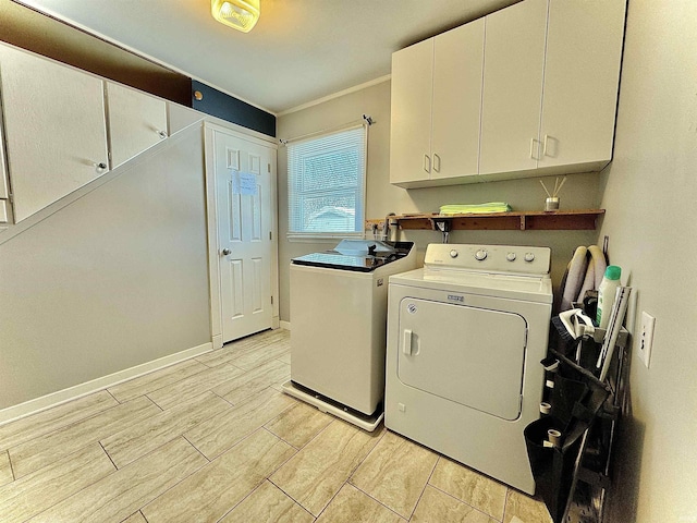 laundry room with cabinets, ornamental molding, and washing machine and dryer