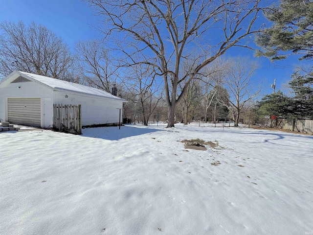 yard layered in snow featuring a garage