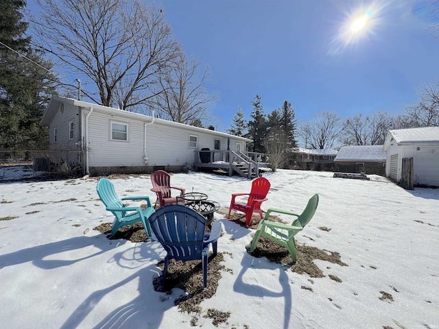 snow covered property with a storage shed