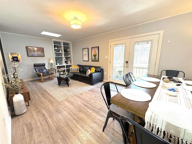 dining area featuring french doors, built in features, and light hardwood / wood-style flooring