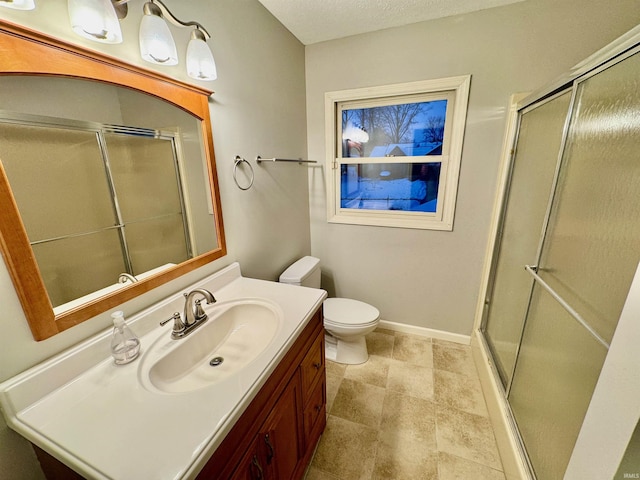 bathroom featuring an enclosed shower, vanity, and toilet