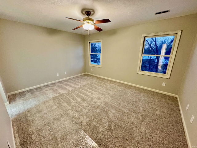 spare room featuring ceiling fan, carpet floors, and a textured ceiling