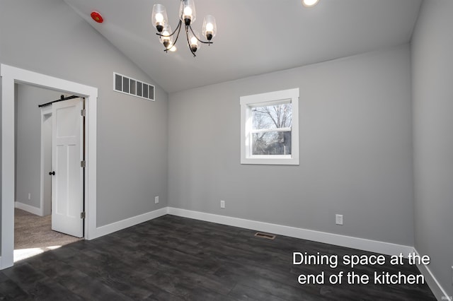 unfurnished room with a notable chandelier, a barn door, dark wood-type flooring, and lofted ceiling