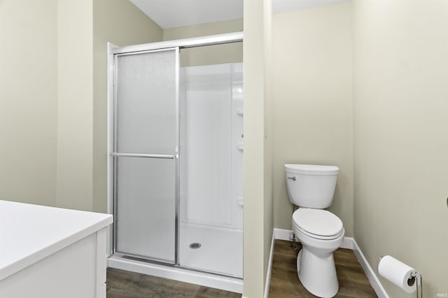 bathroom with walk in shower, hardwood / wood-style floors, vanity, and toilet