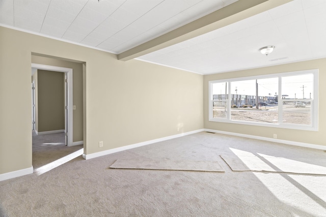 unfurnished room with ornamental molding, carpet, and beam ceiling