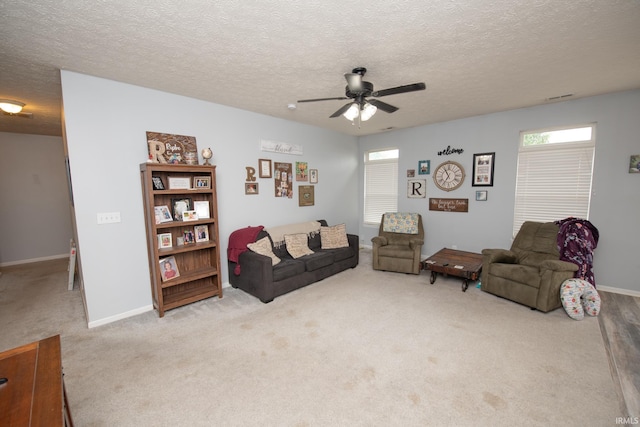 carpeted living room featuring ceiling fan and a textured ceiling