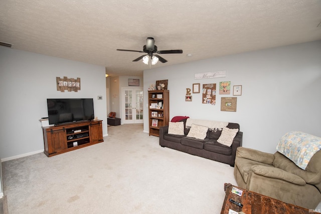 living room featuring french doors, ceiling fan, carpet, and a textured ceiling